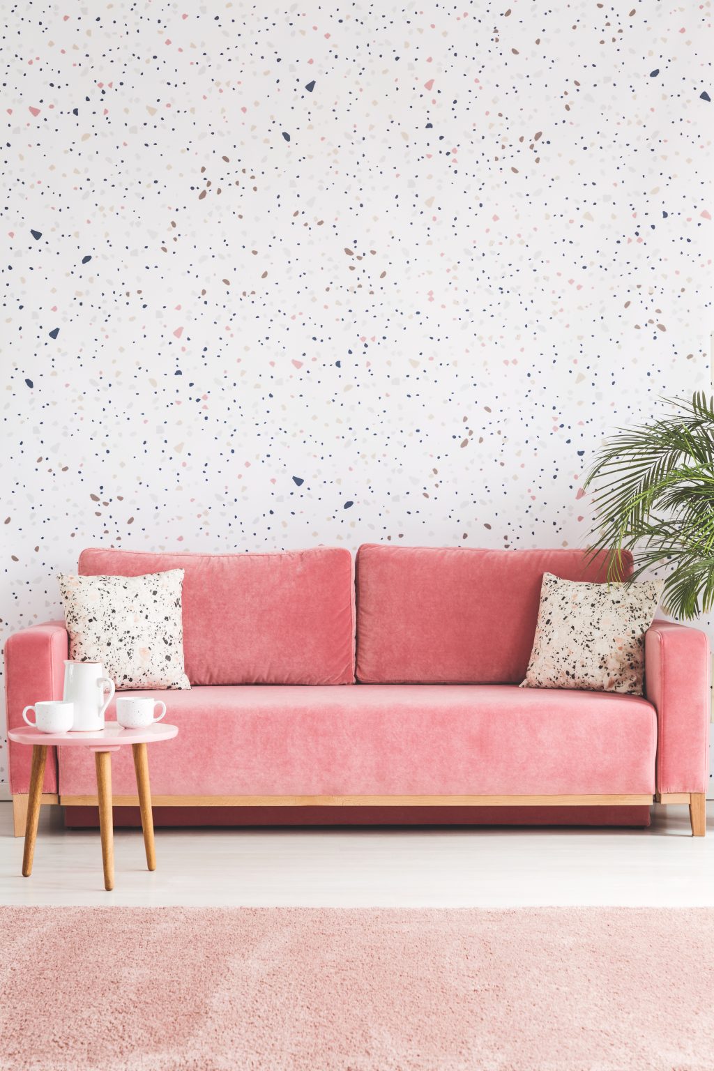 Pillows on pink sofa against lastrico wallpaper in living Pillows on pink sofa against lastrico wallpaper in living